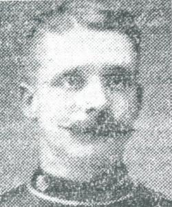 Head and shoulder shot in high neck uniform. High forehead and mustache