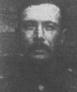 Head and shoulder shot in high neck uniform. high forehead and mustache