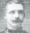 Head and shoulder shot in high neck uniform. High forehead and mustache